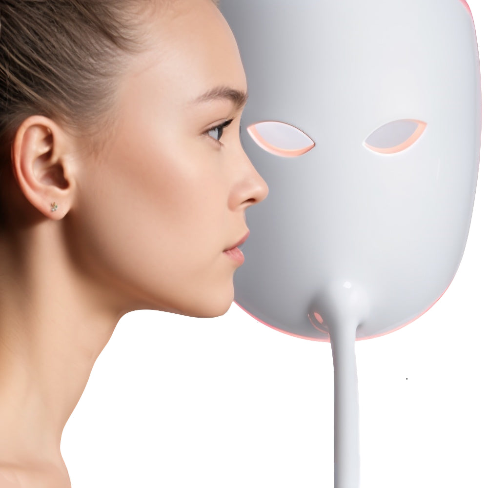A woman in profile facing a Lucibel.le LED mask that emits a soft red light, illustrating the first step in becoming a Lucibel.le ambassador: applying and promoting the product.